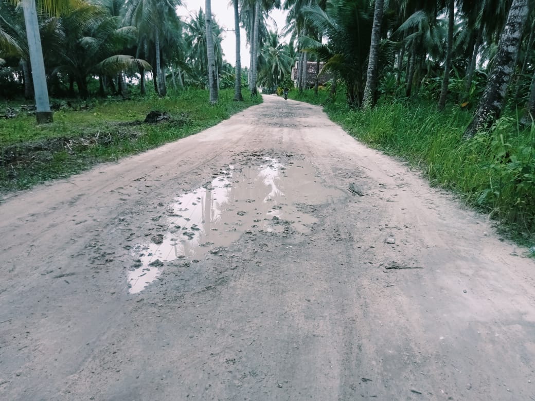 Fasilitas Kesehatan Terbatas: Eksterior atau interior sederhana Puskesmas Pembantu (Pustu) di pulau. Menggambarkan titik layanan kesehatan pertama dan terakhir yang sangat bergantung pada pasokan dari luar.